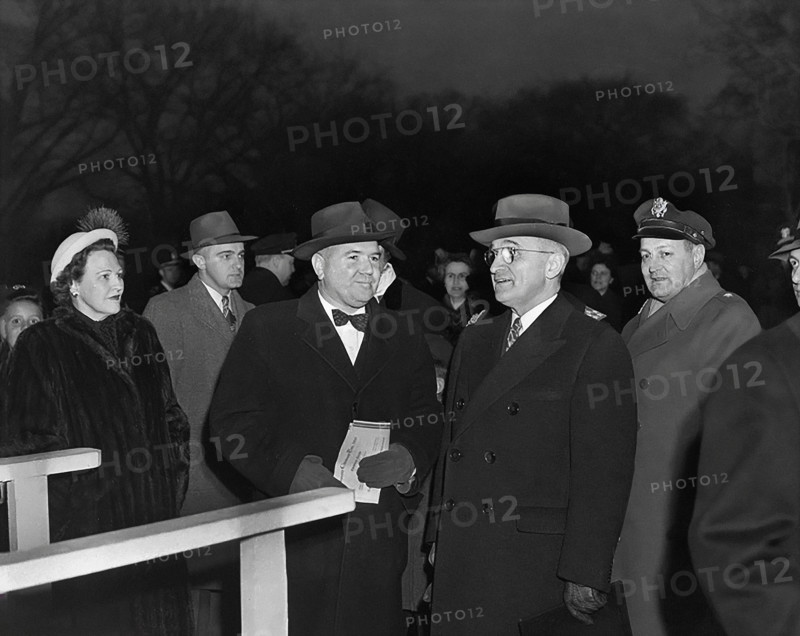 U.S. President Harry S. Truman (second from right) at lighting of the National Community Christmas Tree on White House grounds, flanked by several unidentified people and U.S. General Harry Vaughan, his Military Aide (behind the President's left shoulder), Washington, D.C., USA, Abbie Rowe, National Parks Service, Harry S. Truman Library, December 24, 1945