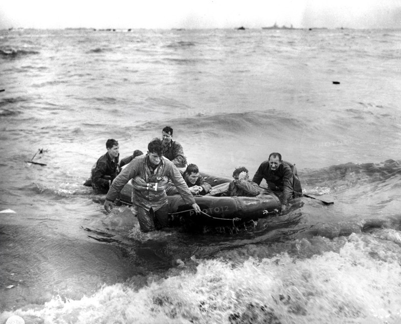 Survivors of sunken LCVP off coast come safely ashore in rubber life raft, Omaha beach, Cherbourg Area, France, Weintraub, U.S. Army Signal Corps, June 6, 1944