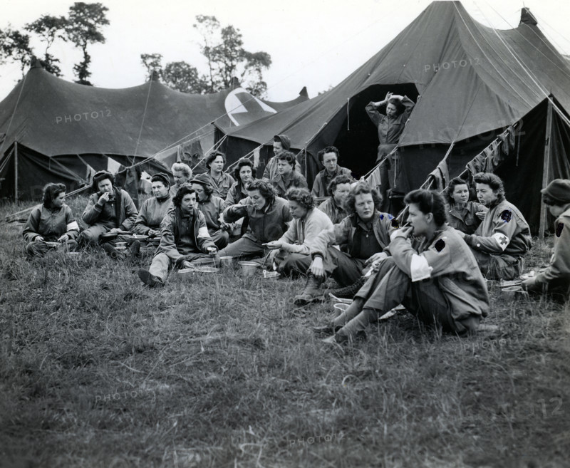 Group of U.S. Army nurses, first to land with the vanguard of American troops, eating dinner at field hospital, Normandy, France, U.S. Army Signal Corps, June 15, 1944
