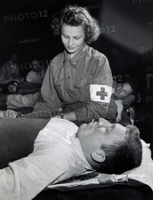 Lt. Elizabeth Babarsik, Canton, Ohio, checking temperature of Private John L. Bennett, Reading, Pennsylvania at field hospital, Normandy, France, U.S. Army Signal Corps, July 5, 1944
