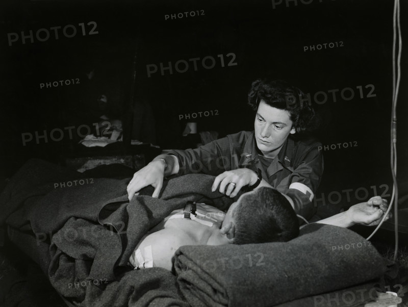 Lt. Ann Howe, Boston, Massachusetts, a U.S. Army nurse, attending a G.I. with lung wound in an evacuation hospital, Normandy, France, U.S. Army Signal Corps, July 3, 1944