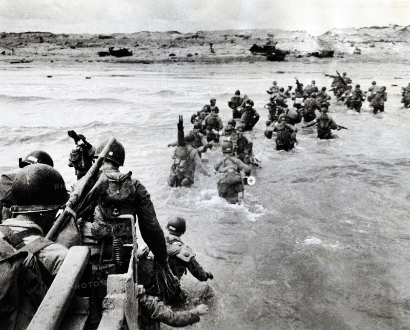 American troops plunge into surf and wade shoreward carrying equipment, Utah Beach, La Madeleine, Normandy, France, Shelton, U.S. Army Signal Corps, June 6, 1944