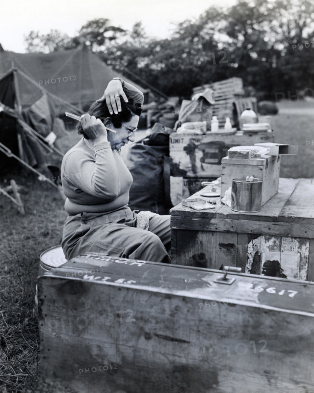 U.S. Lieutenant Frances Y. Slanger, U.S. Army nurse of Boston, Massachusetts, and one of the first nurses to arrive in the wake of the invading armies, taking time out from her arduous duties at a field hospital to fix her hair, Normandy, France, U.S. Army Signal Corps, June 15, 1944