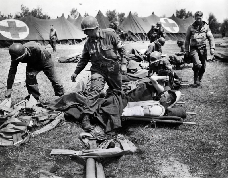 U.S. Army medics making their patients comfortable and begin to distribute life belts to them at a beachhead field hospital in Normandy, France, while they wait to be loaded onto LST's for the return trip to England, U.S. Army Signal Corps, June 11, 1944