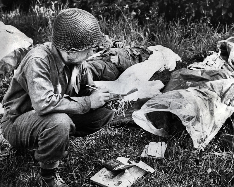 U.S. Sergeant Peter F. Slusarezyk, attached to the Medical Department, tagging a dead American soldier, Sainte-Mere-Eglise, France, U.S. Army Signal Corps, June 7, 1944