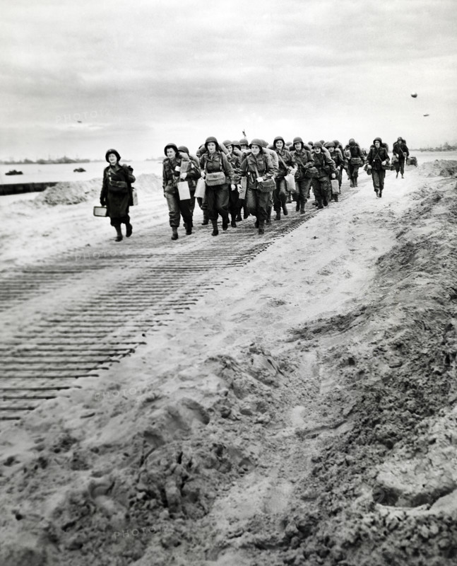 First arrivals of U.S. Women's Army Corps marching from disembarkation pier to transportation and trucks, Normandy, France, U.S. Army Signal Corps, July 15, 1944
