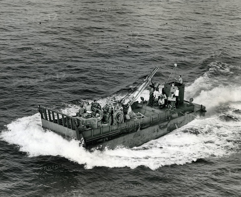 Small landing boat transporting artillery and machinery back and forth between ships and beachhead, Normandy, France, U.S. Army Signal Corps, August 15, 1944