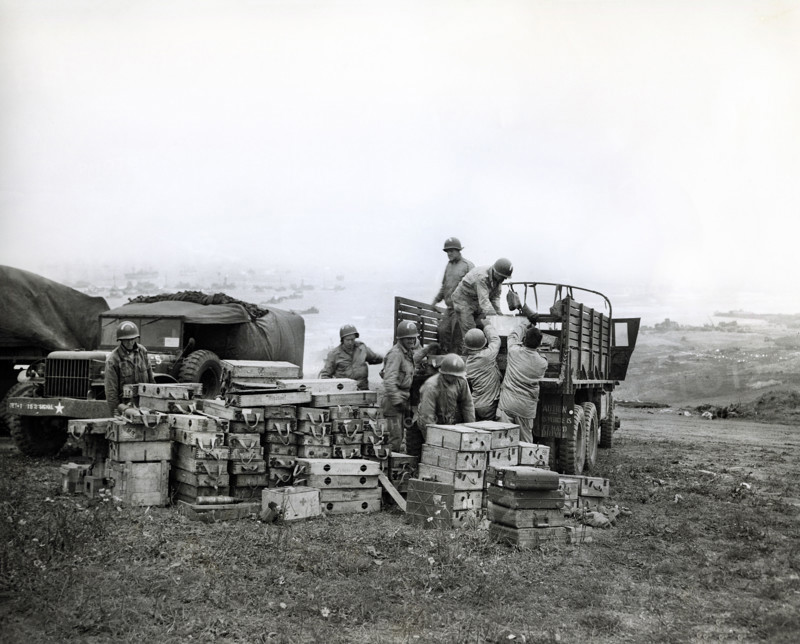 American members of 616th Ordnance Company load ammunition for the famed German 88 gun onto a truck to be salvaged, Omaha Beach, Normandy, France, U.S. Army Signal Corps, June 20, 1944