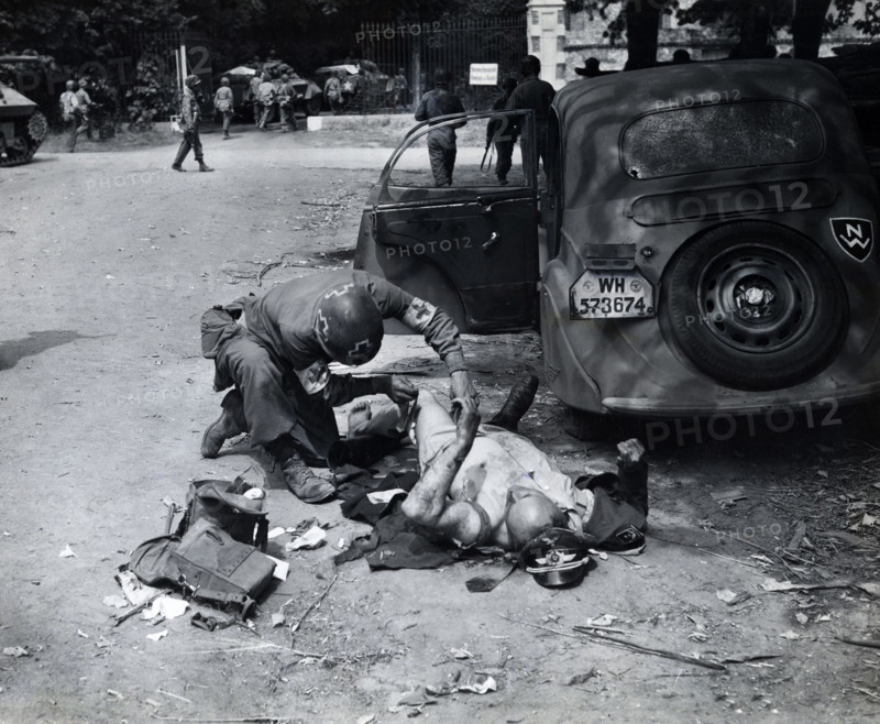 American medic giving first aid to wounded German officer, Chartres, France, U.S. Army Signal Corps, August 15, 1944