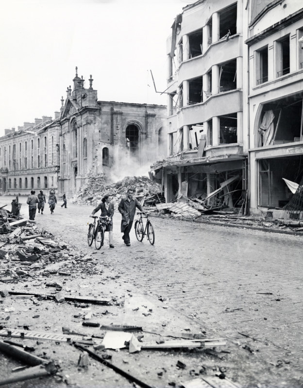 Residents move past bombed buildings hit by German Luftwaffe in an attempt to destroy bridge over Meuse River to delay advance of Allied forces, Verdun, France, U.S. Army Signal Corps, September 2, 1944