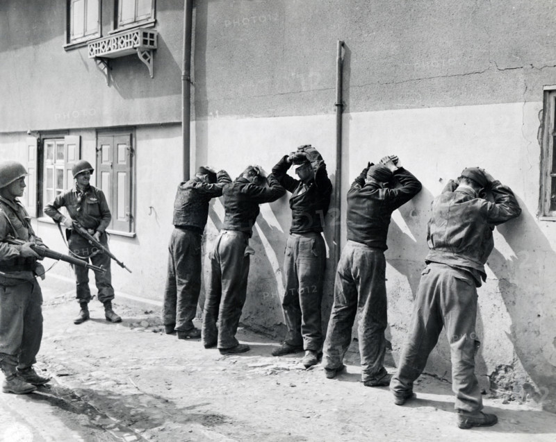Pfc. Herbert Lusk and Sgt. Joseph F. Mannix guard SS troops captured by units of U.S. 1st Infantry Division, U.S. First Army, Dorsten, North Rhine-Westphalia, Germany, U.S. Army Signal Corps, April 11, 1945