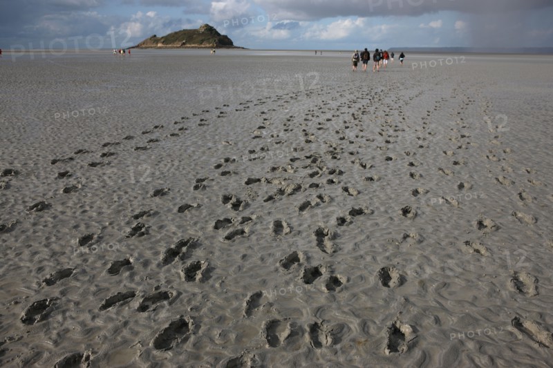 France, Normandie, Manche, baie du Mont-Saint-Michel, traversee des greves, maree basse, rocher tombelaine, , ciel d'orage, randonnee, traces de pas dans la vasiere, guide des chemins de la baie,