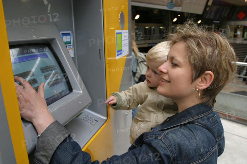 France, Paris 14e, gare Montparnasse, jeune femme et bebe, billeterie automatique, personnages OK, billet, train, sncf,