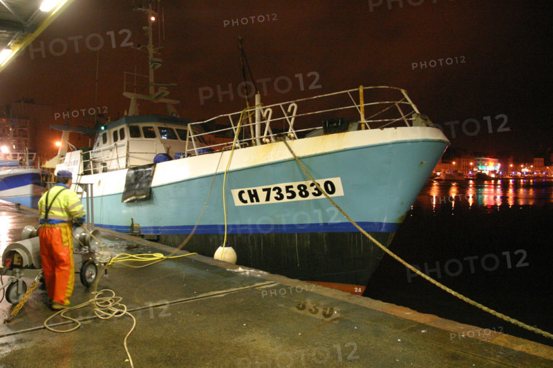 France, Basse Normandie, Manche, Cotentin, Cherbourg, bassin du commerce, centre de maree, debarque de nuit d'un chalutier a quai, lumieres de la ville,