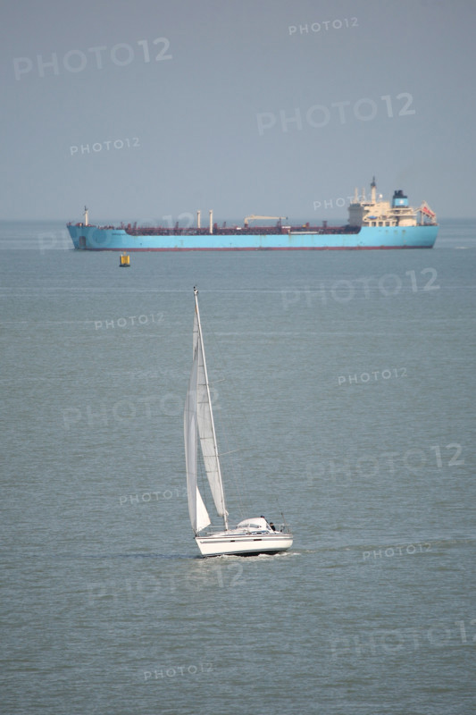 France, Haute Normandie, au large de la cote d'albatre, mer Manche, cargo en provenance du havre et petit voilier, bateau de plaisance,