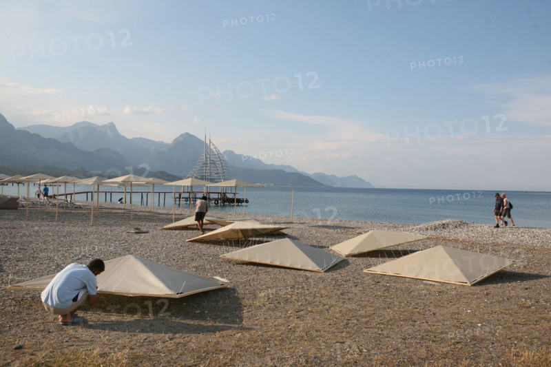 Turquie, sud d'antalya, kemer, riviera turque, station balneaire, debut de saison touristique, hotel, plage au pied des montagnes, preparation de la grande saison, hotel, parasols en cours de montage,