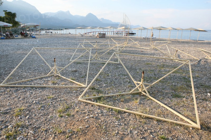 Turquie, sud d'antalya, kemer, riviera turque, station balneaire, debut de saison touristique, hotel, plage au pied des montagnes, preparation de la grande saison, hotel, parasols en cours de montage,