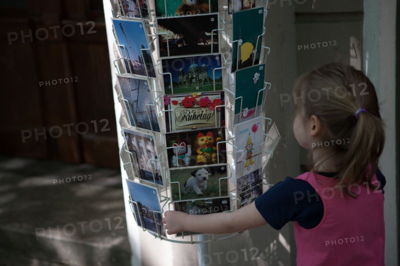 Allemagne (Germany), Berlin, Friedrichshain, immeuble, ancien Berlin Est, enfant devant un presentoir de cartes postales