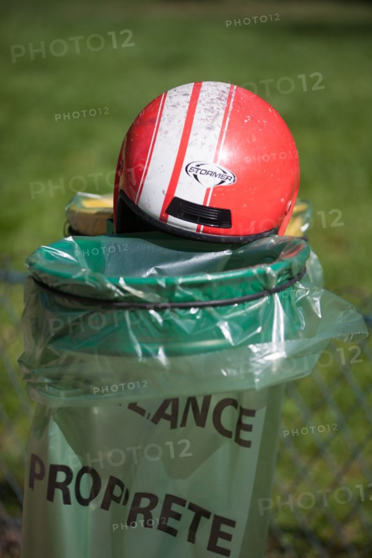 France, Région Ile de France, Paris 8e arrondissement, Parc Monceau, casque de moto rouge posé sur les poubelles vertes et jaunes