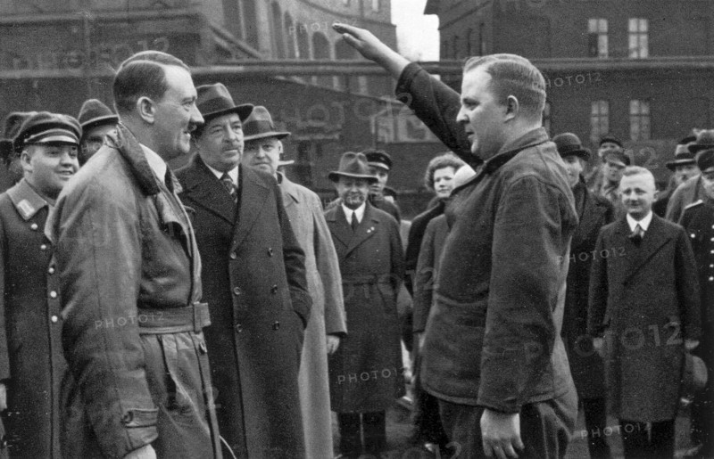 Adolf Hitler. Besuch in einer Fabrik. Ein Vertreter der Belegschaft begrüßt den Führer. Visite d'une usine. Un représentant du personnel salue le Führer.