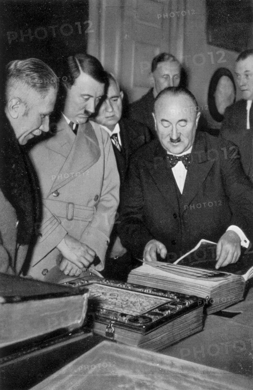 Adolf Hitler. Anläßlicht der Ubereignung einer von ihm erworbenen wertwollen Handschrift läßt sich der Führer die Schätze der Bayrischen Staatsbibliothek zeigen. Le Führer se fait montrer le trésor des manuscrits de la bibliothèque bavaroise.
