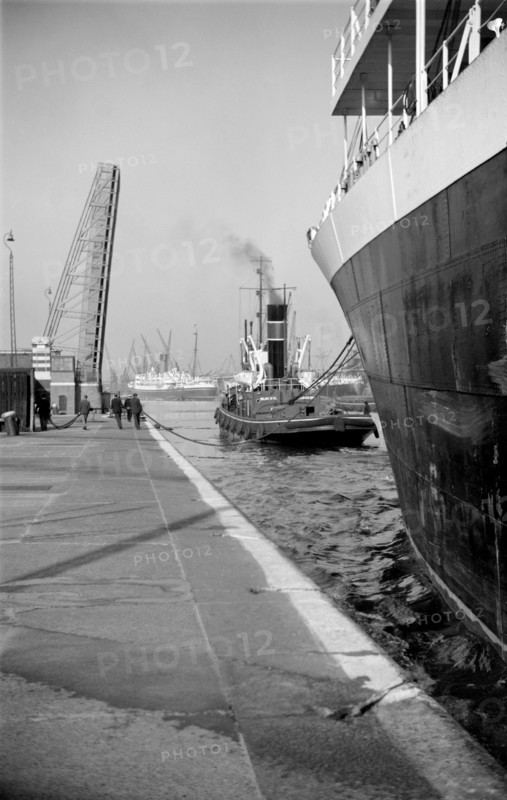 A ship being towed into the King George V Dock, Canning Town, London, c1945-c1965