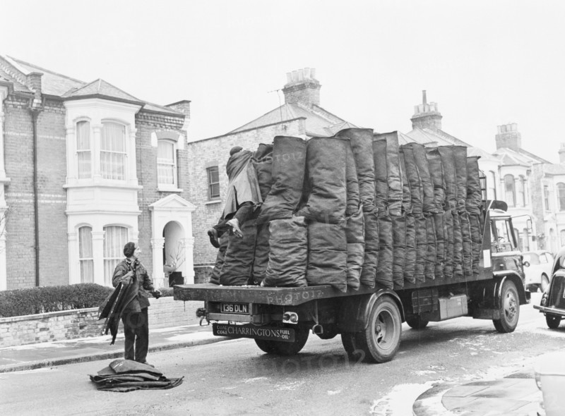 Charringtons delivering sacks of coal down a residential street. Artist: Unknown