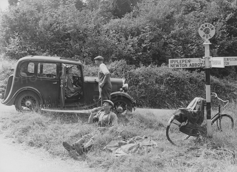 People relaxing by a signpost with a 1935 Standard 10 hp car, Devon, (c1935?). Artist: Unknown