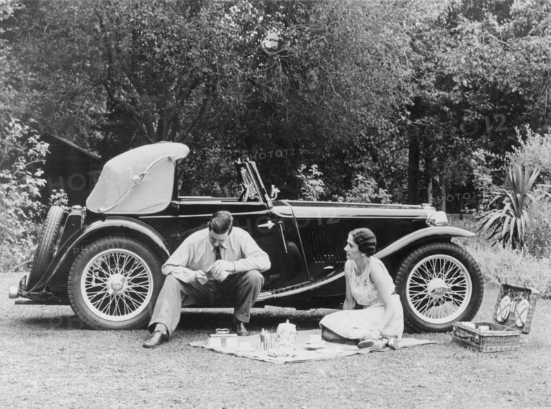Couple having a picnic by an MG TA Midget, late 1930s. Artist: Unknown
