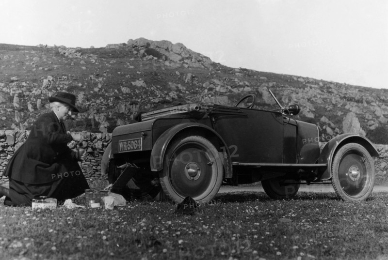 A woman picnicking next to her air-cooled Rover 8, c1919-c1925. Artist: Unknown