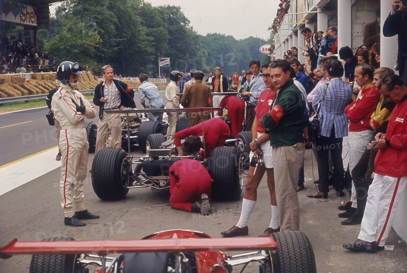 Graham Hill watches Mechanics working on a car, French Grand Prix, Rouen, 1968. Artist: Unknown