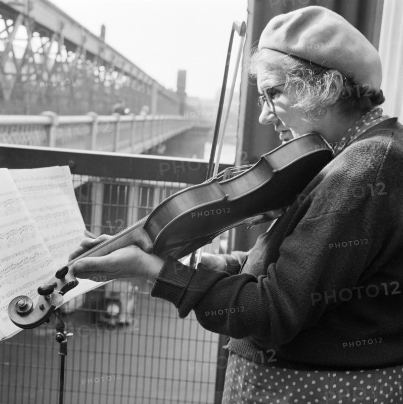 Woman busker playing the violin, Hungerford Bridge, London, 1946-1959