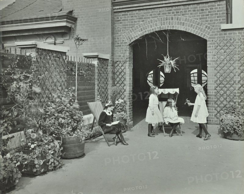 Girls relaxing in a roof top garden, White Lion Street School, London, 1912. Artist: Unknown.