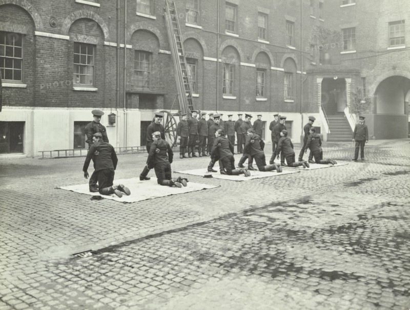 Demonstrating how to pick up an unconscious person, London Fire Brigade Headquarters, London, 1910. Artist: Unknown.