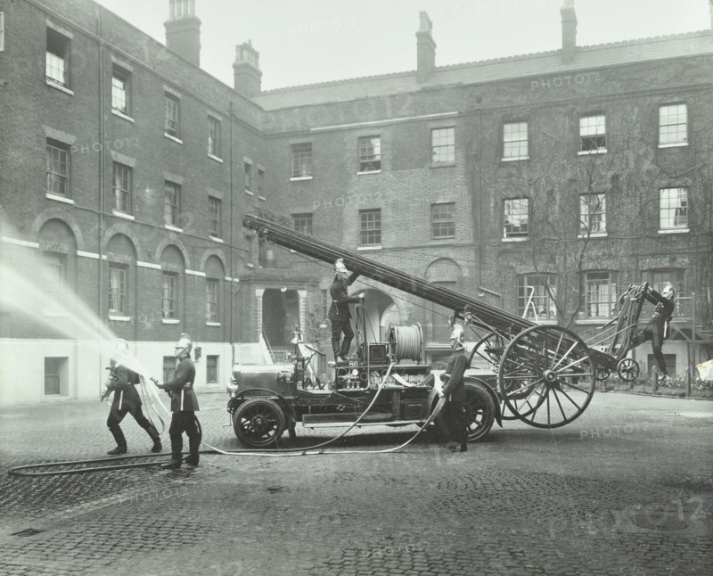 Fireman using a hose, London Fire Brigade Headquarters, London, 1910. Artist: Unknown.