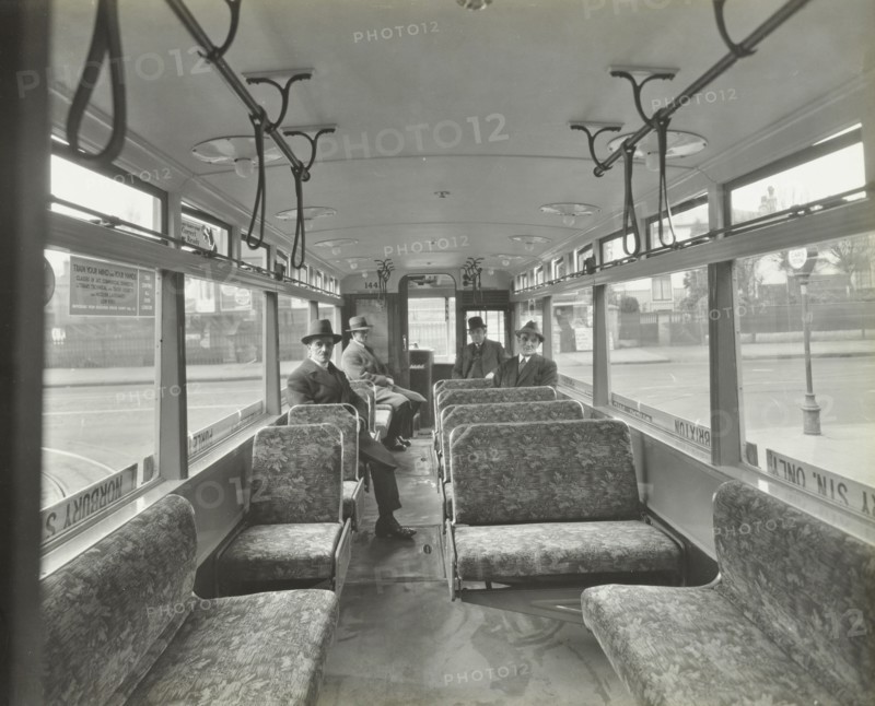 Men in hats and coats in the interior of an electric tram, London, 1933. Artist: Unknown.