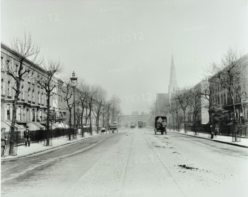 Broad tree-lined street with tramlines, Burdett Road, Stepney, London, 1912. Artist: Unknown.