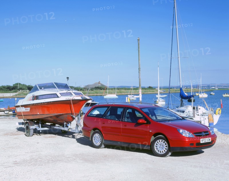 2002 Citroen C5 hdi towing a boat by harbour. Artist: Unknown.