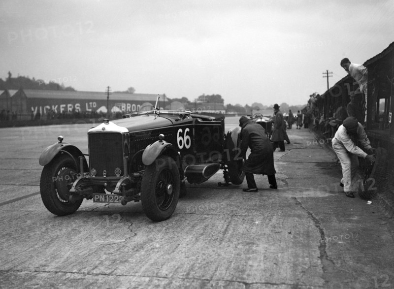 GL Baker's 5954 cc Minerva undergoing a rear wheel change at Brooklands. Artist: Bill Brunell.