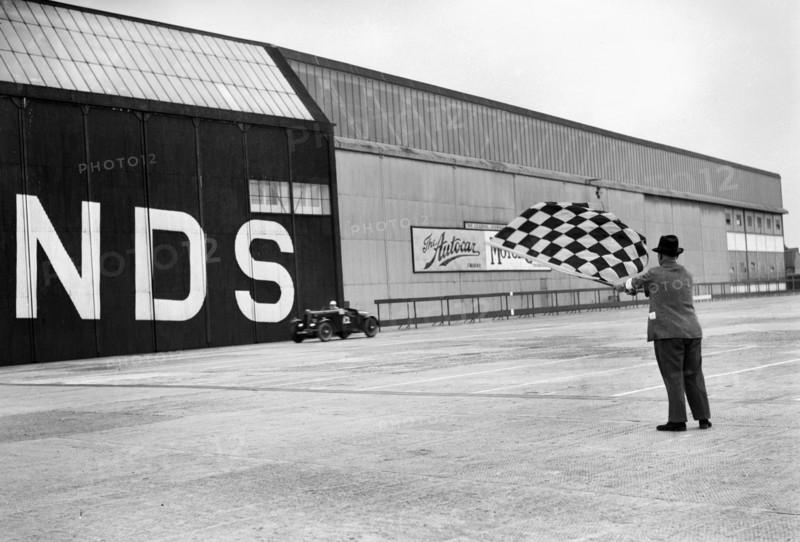 Waving the chequered flag at Brooklands, 1938 or 1939. Artist: Bill Brunell.