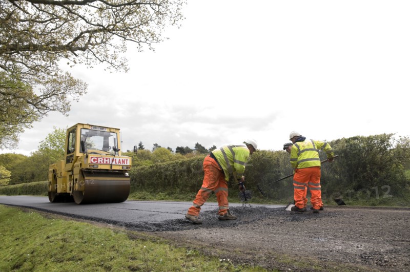 Road resurfacing work repairing potholes Artist: Unknown.