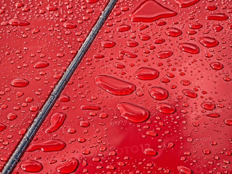 Raindrops beading on classic car paintwork