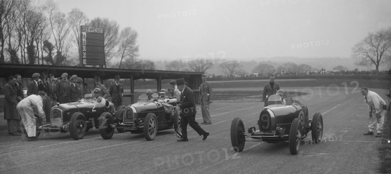 Alfa Romeo and two Bugatti Type 35s on the start line, Donington Park, Leicestershire, 1935. Artist: Bill Brunell.