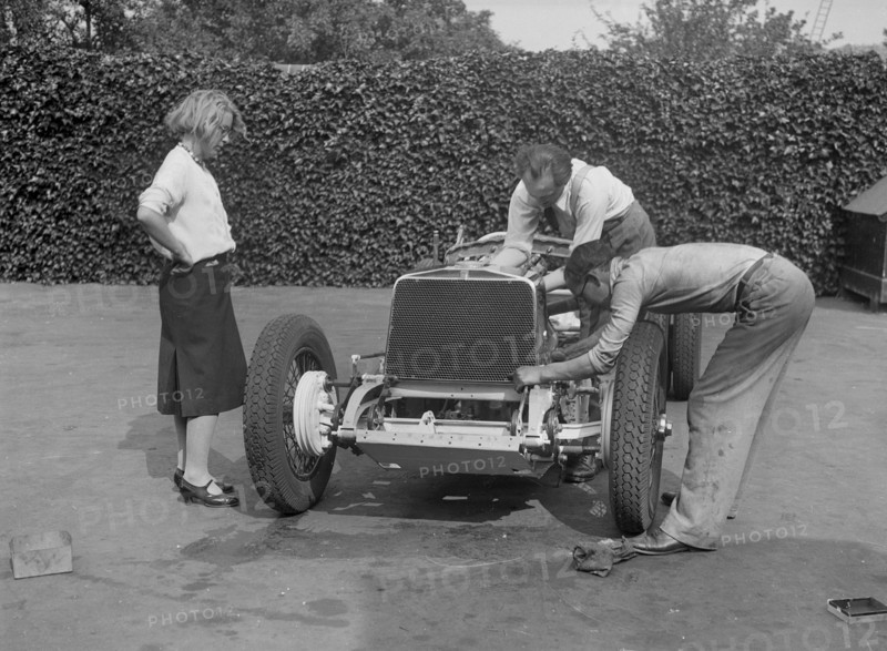 Working on the engine of Raymond Mays' Vauxhall-Villiers, c1930s. Artist: Bill Brunell.