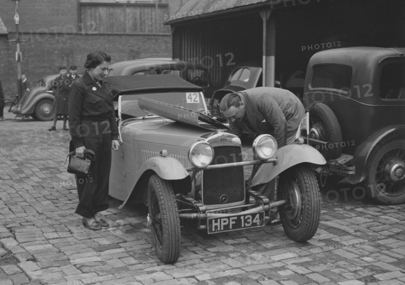 AES Curtis looking under the bonnet of his HRG at the RAC Rally, 1939. Artist: Bill Brunell.