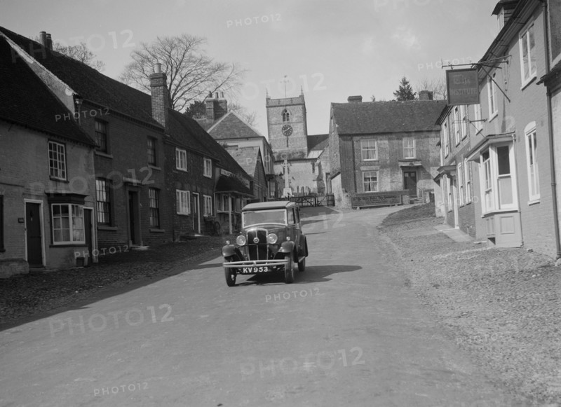 Standard Sixteen saloon driving down the High Street, Hambledon, Hampshire, 1930s. Artist: Bill Brunell.