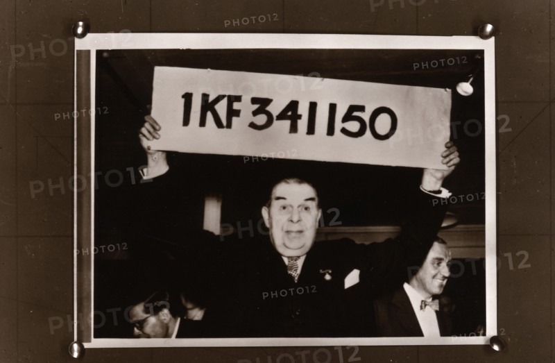 Lord Mackintosh holds up the first winning premium bond number, 1966. Artist: Unknown