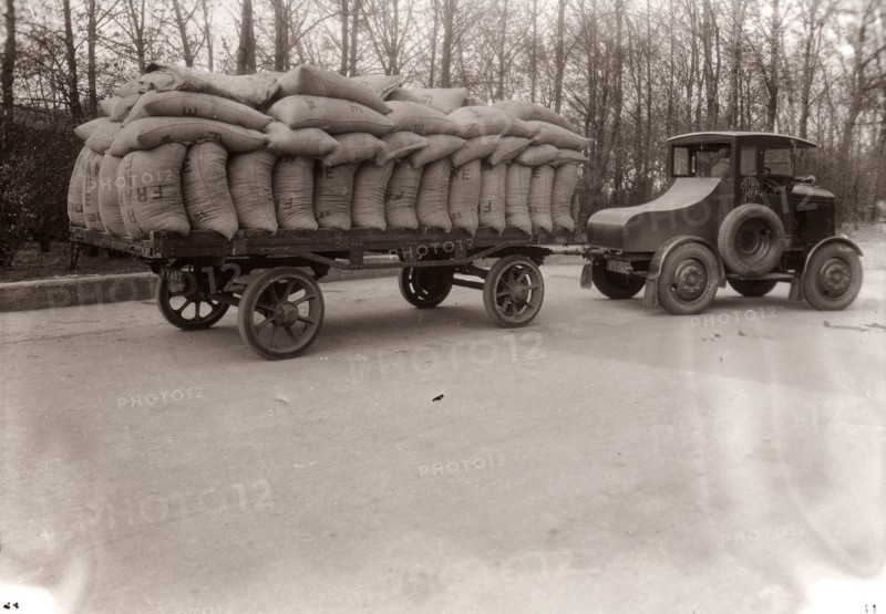 A tractor pulling a trailer loaded with sacks, 1928. Artist: Unknown