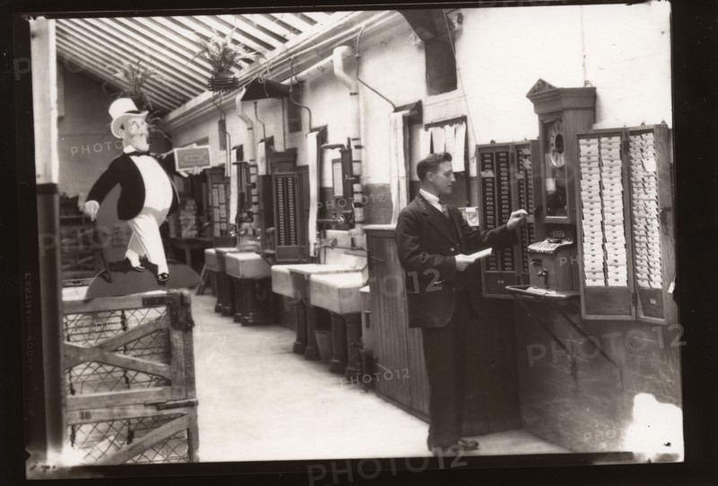 A man uses the clocking in machine, Rowntree factory, Yorkshire, 1929. Artist: Unknown