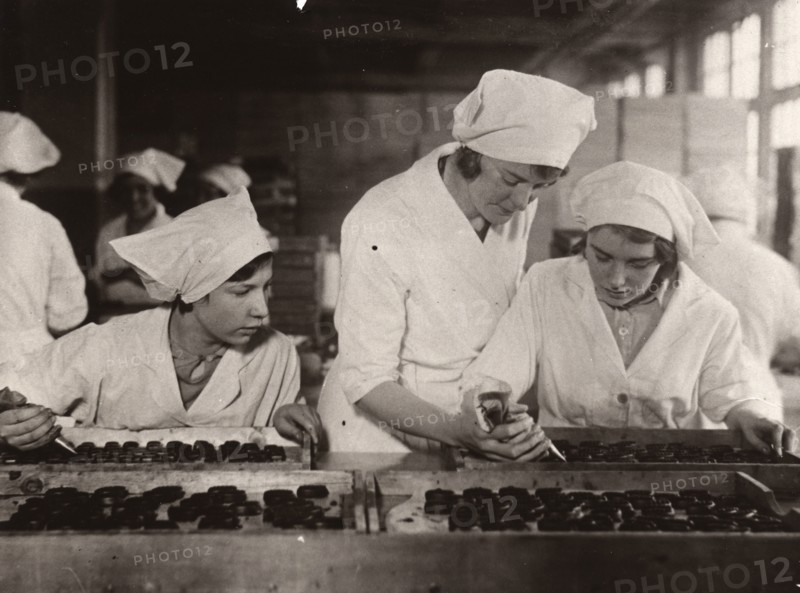 A girl is taught how to hand-pipe chocolates, Rowntree factory, York, Yorkshire, 1933. Artist: Unknown